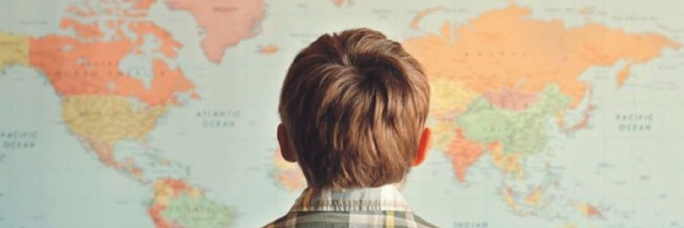Boy looking at world map