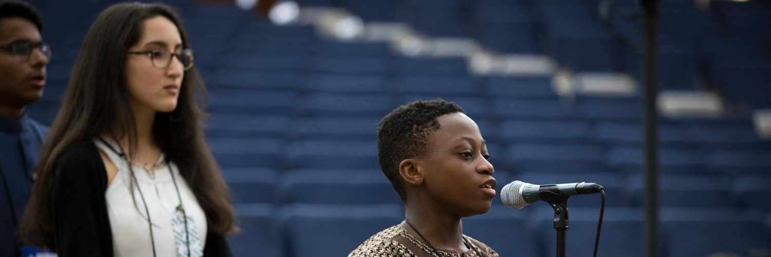 Black person speaking into microphone